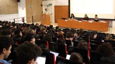 Estudiants asseguts i assegudes a les cadires de l'aula magna de la Facultat de Comunicació.